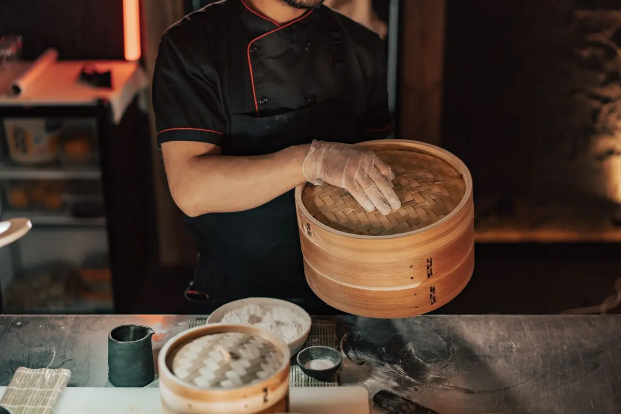 Chef preparing dishes in bamboo steamer baskets